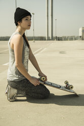 Junge Frau mit Skateboard auf Parkdeck - UUF000226