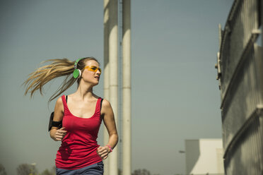 Young woman with headphones jogging - UUF000235