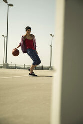Junge Frau spielt Basketball im Freien - UUF000239