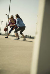 Zwei junge Frauen spielen Basketball im Freien - UUF000240