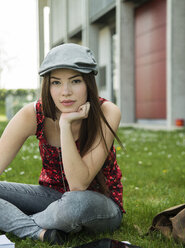 Brunette young woman sitting on meadow - UUF000295