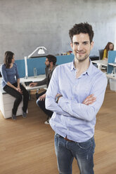 Portrait of man standing in the open space office - RBF001638