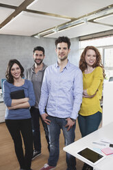 Gruppenbild von vier Kollegen, die im Büro stehen - RBF001640