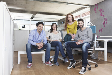 Gruppenbild von vier kreativen Menschen, die im Büro sitzen - RBF001687