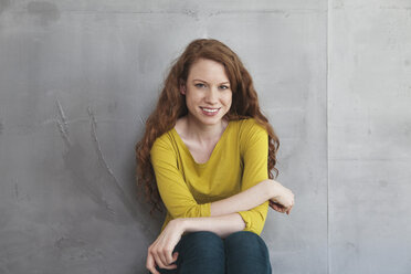 Portrait of smiling woman in front of grey wall - RBF001688