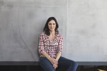 Portrait of smiling woman in front of grey wall - RBF001668