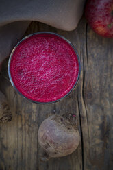 Glass of apple beetroot smoothie on dark wooden table, elevated view - LVF001045