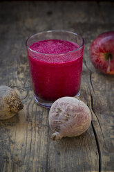 Glass of apple beetroot smoothie on dark wooden table - LVF001046