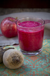 Glass of apple beetroot smoothie, apple and two beetroots on table - LVF001048