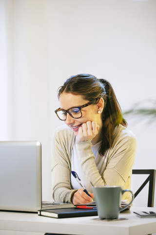 Frau arbeitet im modernen Heimbüro, lizenzfreies Stockfoto