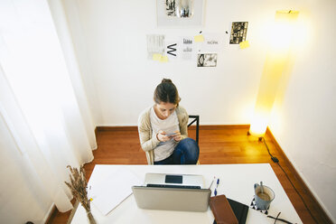 Frau mit Smartphone im modernen Heimbüro, Blick von oben - EBSF000156