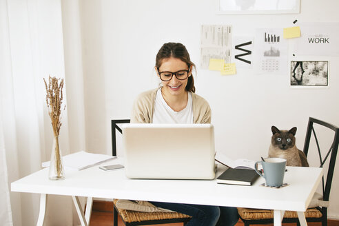 Woman and her cat sitting at desk - EBSF000177