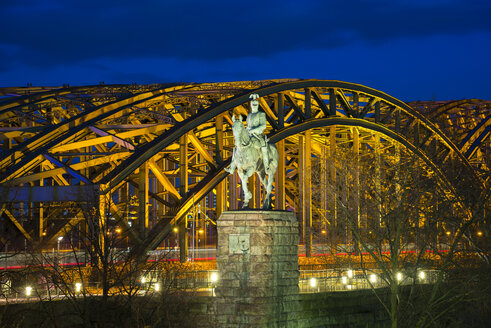 Germnay, Nordrhein-Westfalen, Köln, Reiterstandbild von Kaiser Wilhelm II. vor der beleuchteten Hohenzollernbrücke bei Nacht - WGF000274