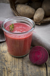 Preserving jar of beetroot potato soup, cloth and beetroot on dark wood - LVF001052