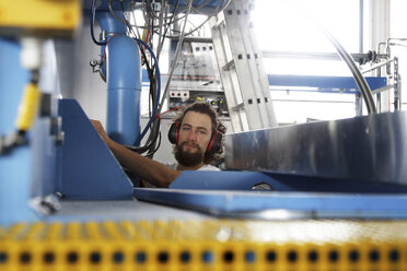 Techniker an einer Maschine in einer Fabrikhalle - SGF000570