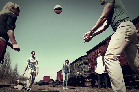 Gruppe von fünf Freunden spielt Volleyball, lizenzfreies Stockfoto