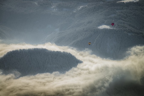 Austria, Salzkammergut, Hot air ballons over forest stock photo