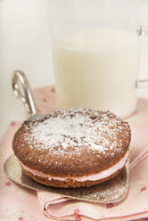 Garnierter Whoopie Pie auf Tortenheber vor einem Glas Buttermilch - CSTF000251