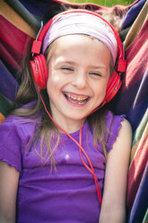 Portrait of laughing little girl with red headphones - SARF000497