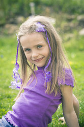 Porträt eines lächelnden kleinen Mädchens, das im Garten sitzt - SARF000496