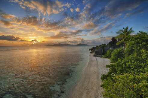 Seychelles, La Digue, view to Anse Source d' Argent with sculpted rocks and palm trees at sunset - RUEF001234