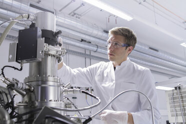 Wissenschaftlerin im analytischen Labor mit Rasterelektronenmikroskop und Spektrometer - SGF000588