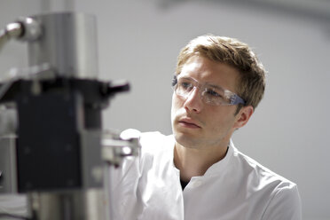 Porträt eines Wissenschaftlers bei der Arbeit am Spektrometer im analytischen Labor - SGF000587