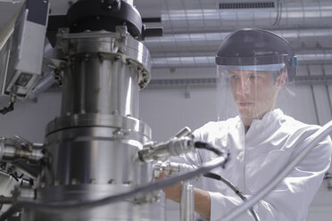 Scientist standing in analytical laboratory with scanning electron microscope and spectrometer - SGF000584