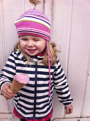 Girl with striped hat eating a raspberry ice cream in waffle cone, Germany - IPF000111