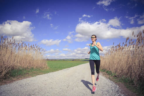 Frau joggt durch die ländliche Landschaft - VTF000213