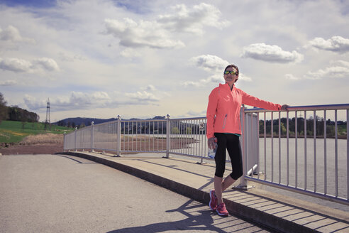 Joggerin macht eine Pause auf einer Brücke - VTF000209