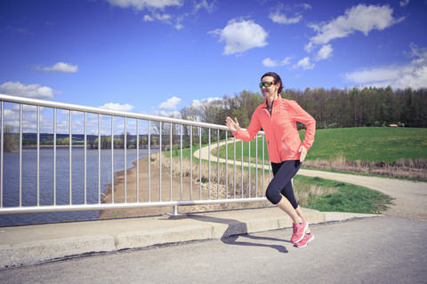 Frau joggt über eine Brücke, lizenzfreies Stockfoto