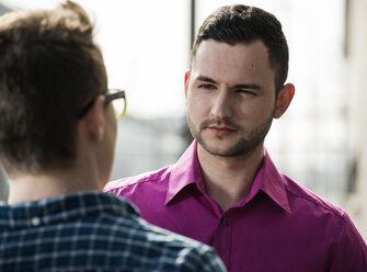 Portrait of serious looking man talking to teenager - UUF000313