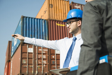 Geschäftsmann im Gespräch mit Teenager am Containerterminal - UUF000325