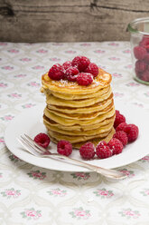 Stack of pancakes with honey, raspberries and icing sugar on plate - LVF001101