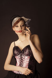 Porträt einer jungen Frau mit Lippenstift auf der Wange im Stil der 20er Jahre gekleidet - FBF000374