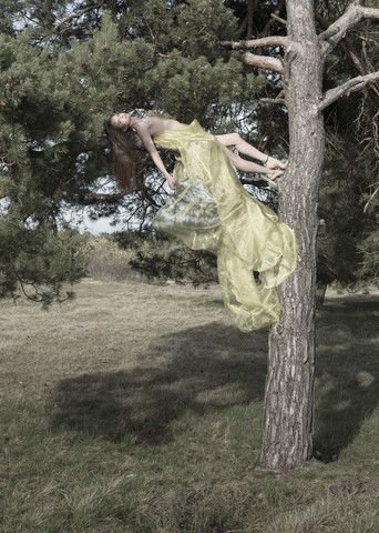 Germany, Bavaria, Froettmaning Heath, young woman lying on an branch stock photo