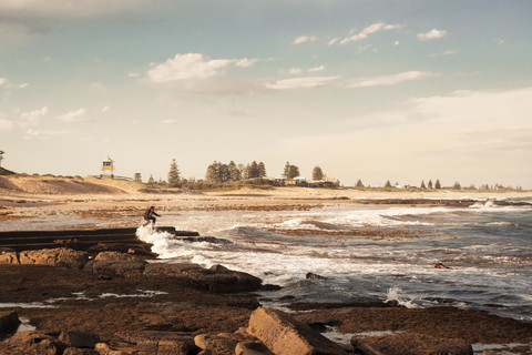 Australien, New South Wales, Teegärten, Mann am Strand in der Flut, lizenzfreies Stockfoto