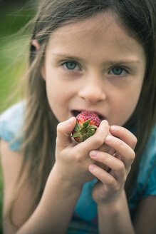 Porträt eines kleinen Mädchens, das eine Erdbeere isst - SARF000521