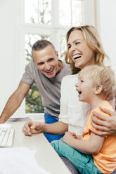 Happy grandfather, mother and son at desk - MFF001058