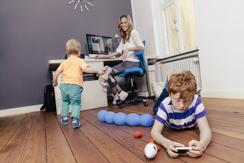 Mutter mit zwei Söhnen im Arbeitszimmer, lizenzfreies Stockfoto