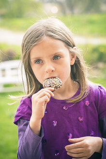 Porträt eines kleinen Mädchens, das Cake Pop testet - SARF000529