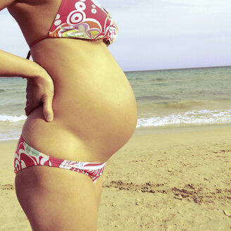 Schwangere Frau am Strand stehend, Fuerteventura, Spanien - DRF000663