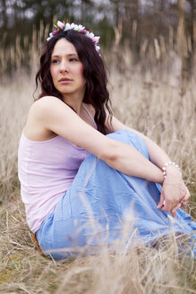 Germany, Young woman sitting on meadow - AFF000054