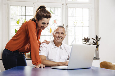 Älterer Mann und junge Frau mit Laptop zu Hause - MFF001053