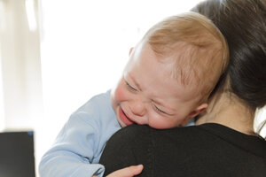 Mother holding crying baby boy - LAF000791