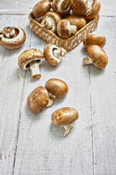 Basket of Crimini mushrooms on grey wooden table - KSWF001258