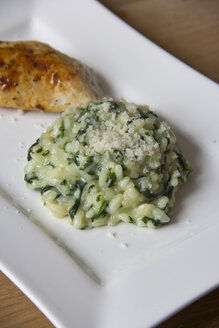 Spinat-Gorgonzola-Risotto mit Parmesan und gebratener Hühnerbrust auf einem Teller - YFF000107