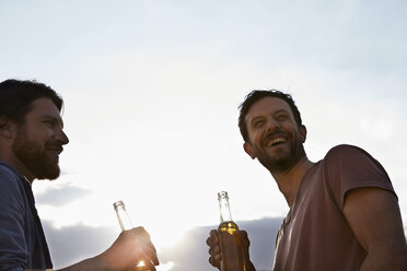 Two friends with beer bottles outdoors - FMKF001177