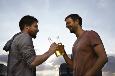 Two friends with beer bottles outdoors - FMKF001178